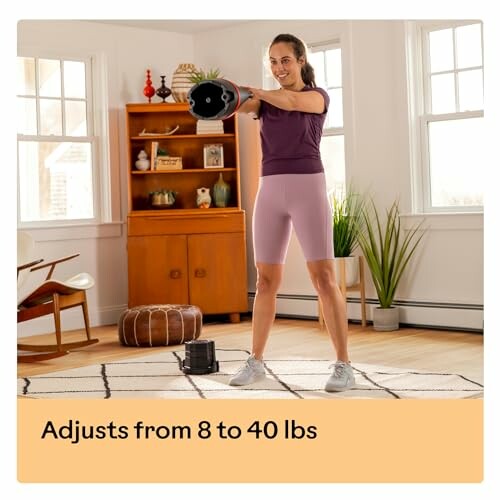 Woman exercising with adjustable dumbbell at home.