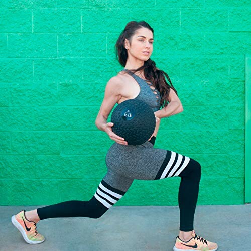 Woman in athletic wear lunging with a medicine ball for a full-body workout.